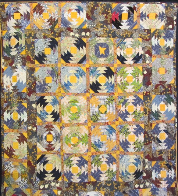 My Best Friend by Nancy Hutchison Scrappy pineapple blocks, created ith fabrics from her late husband's favorite shirts.  Quilting served as therapy following his sudden death.  The backing is an expensive Dallas Cowboy fabric she'd been saving. 